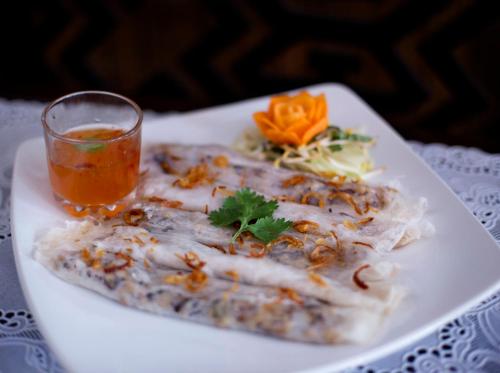 a plate of food with a drink on a table at The Mansion Resort Hotel & Spa in Ubud