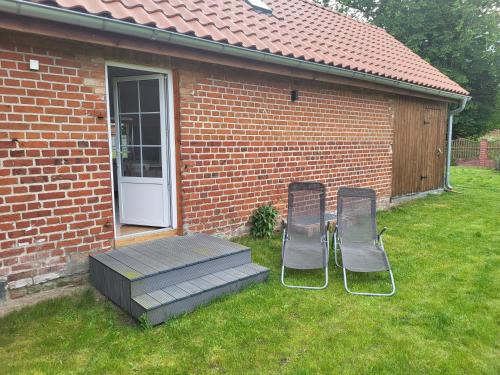 two chairs and a table in a yard next to a building at Rezydencja Masuria in Siemiany