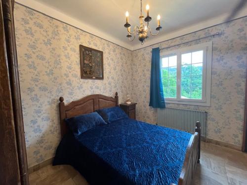 une chambre avec un lit bleu et une fenêtre dans l'établissement Chambres d'hôtes B&B Le Chant des Pins en Cévennes, à Le Collet-de-Dèze
