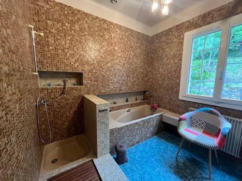 La salle de bains est pourvue d'une baignoire et d'une chaise. dans l'établissement Chambres d'hôtes B&B Le Chant des Pins en Cévennes, à Le Collet-de-Dèze