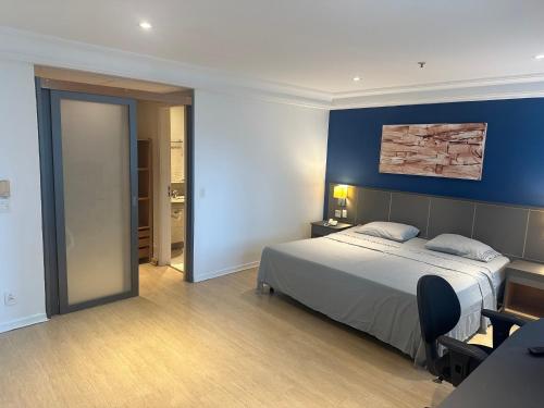 Un dormitorio con una cama y una pared azul. en Mediterrâneo Fantastic, en Río de Janeiro