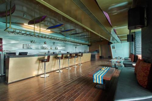 - un bar avec tabourets et un comptoir dans une pièce dans l'établissement Park Prime Kolkata, à Kolkata