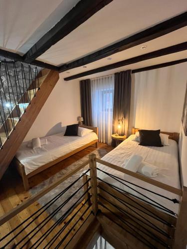 two beds in a room with a staircase at Grotto in Rovinj