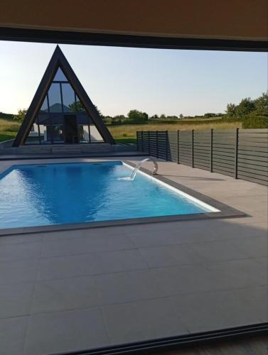 a swimming pool with a pyramid shaped building behind it at Villa Rustic in Majetići