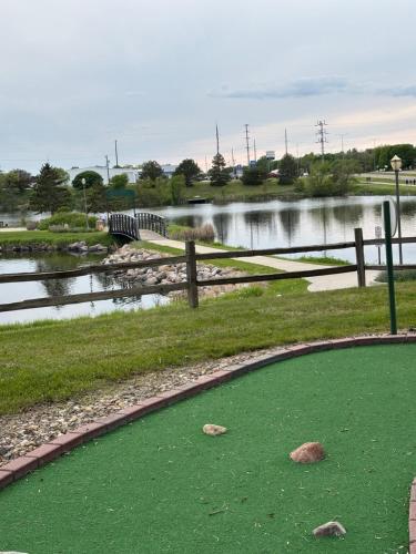 a golf course with a pond and a fence at Dakota Inn in Huron