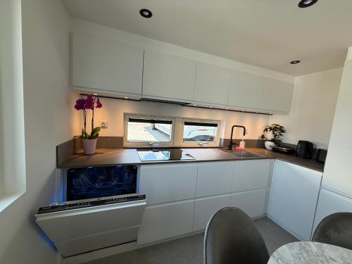 a kitchen with white cabinets and a sink at Nordic Loft Retrat- Deluxe mini villa med 2 sovloft in Mölndal