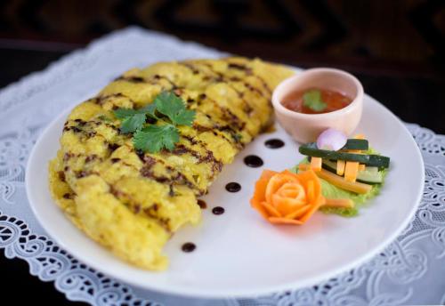 a white plate with food on a table at The Mansion Resort Hotel & Spa in Ubud