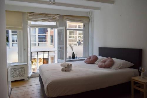 a bedroom with a bed with a teddy bear on it at NEW cosy apartment in 9 streets in Amsterdam