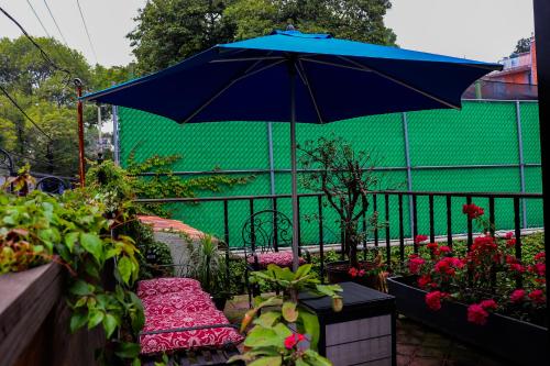 a blue umbrella sitting on a balcony with flowers at Casa Real Coyoacán in Mexico City