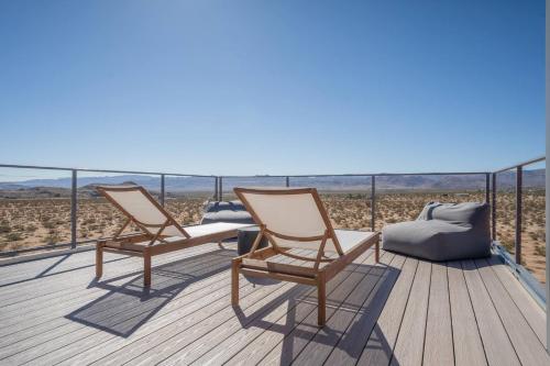 two chairs and a couch on a deck with the beach at 3-Story Container Home | Pool • Spa • Rooftop Deck in Hidden River