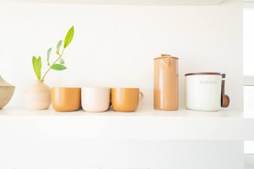 a shelf with a row of different colored cups at 3-Story Container Home | Pool • Spa • Rooftop Deck in Hidden River