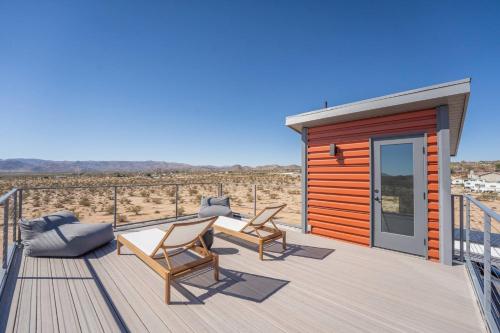 a wooden deck with chairs and a cabin at 3-Story Container Home | Pool • Spa • Rooftop Deck in Hidden River