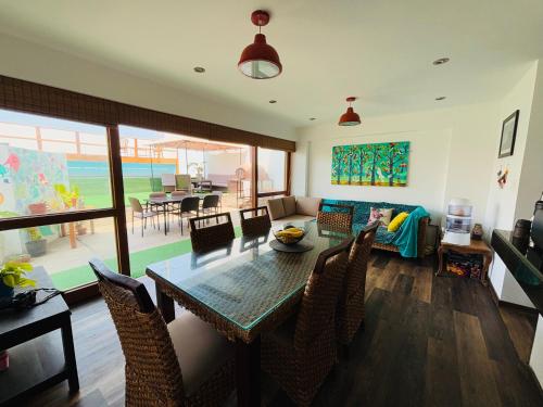 a dining room and living room with a table and chairs at El Templo Surf House in Punta Hermosa