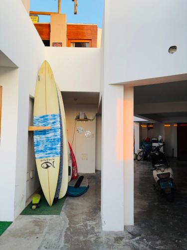 a surfboard is leaning against a wall in a room at El Templo Surf House in Punta Hermosa