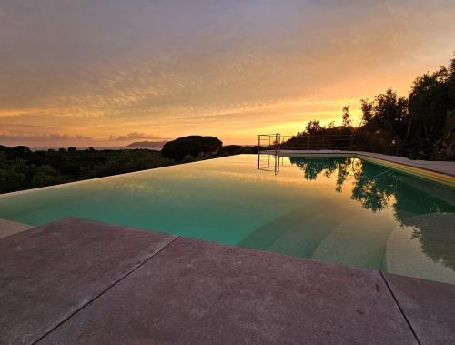 a swimming pool with a sunset in the background at Villa Giove 1 in Terracina