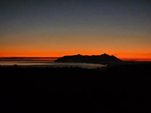 a sunset over the ocean with a mountain in the background at Villa Giove 1 in Terracina