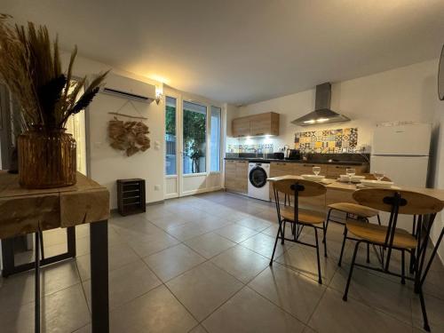 une cuisine avec une table et des chaises ainsi qu'une salle à manger dans l'établissement La Maison de Emma, à Boulbon