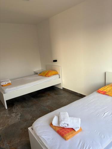 two beds in a room with towels on them at Vila Enesa in Dobra Voda