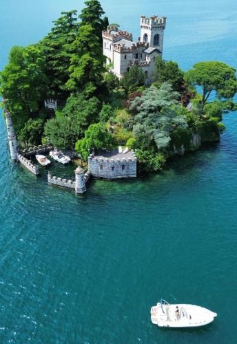 a castle on an island in the water with a boat at Casa Caterina - Riva di Solto - Iseo Lake in Riva di Solto