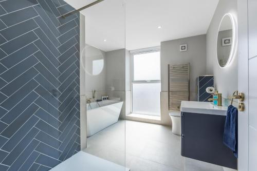a bathroom with a blue and white tile wall at The Mail Rooms Limavady - Boutique Stays in Limavady