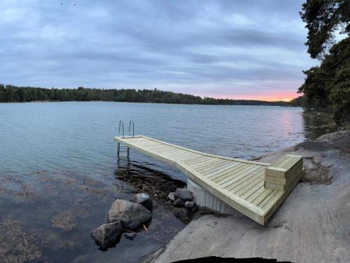 a dock on the shore of a lake at sunset at 6 person holiday home in LOFTAHAMMAR-By Traum in Loftahammar