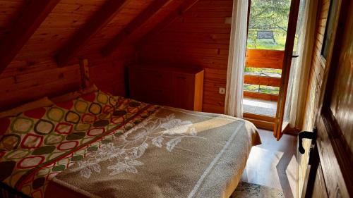 a bed in a wooden room with a window at Holiday Home Stella Star in Žabljak