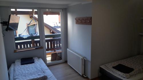 a room with a balcony with a bed and a window at Dom Narciarza in Szczyrk