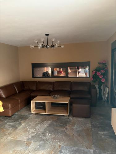 a living room with a brown couch and a table at Vila Enesa in Dobra Voda