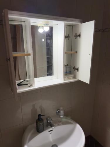 a bathroom sink with a medicine cabinet and a mirror at Caramel Cloud in Mytilene