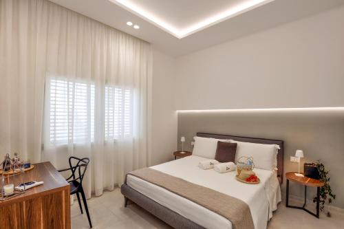a bedroom with a bed and a desk and a window at Daline Holiday Rooms in Acquarica del Capo