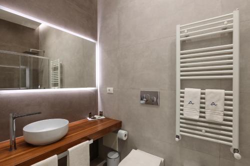 a bathroom with a sink and a toilet and a mirror at Daline Holiday Rooms in Acquarica del Capo