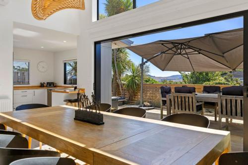 eine Küche und ein Esszimmer mit einem großen Holztisch in der Unterkunft Idyllic Getaway - modern and stylish with private spa in Taupo