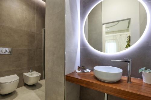a bathroom with a sink and a mirror at Daline Holiday Rooms in Acquarica del Capo