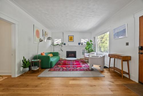 ein Wohnzimmer mit einer grünen Couch und einem Kamin in der Unterkunft Blissful South Hill Retreat in Spokane