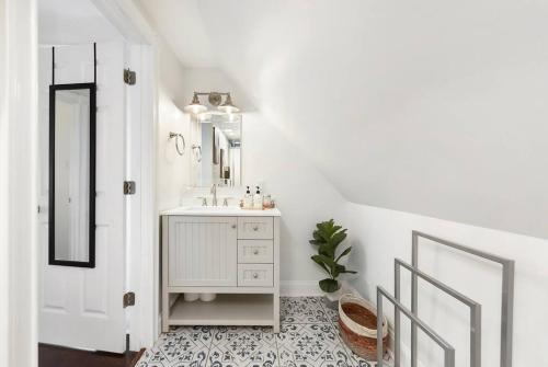 a white bathroom with a sink and a mirror at The Point State Room on Beatty in Pittsburgh
