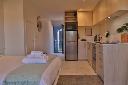 a kitchen with a large bed in a room at Cosy Studio in Awaroa Road in Auckland