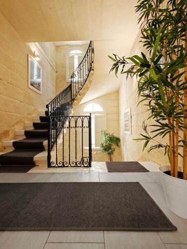 a hallway with a spiral staircase with black railings at Casa Maltija in Sliema