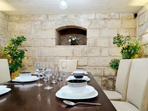 a wooden table with glasses and plates on it at Casa Maltija in Sliema