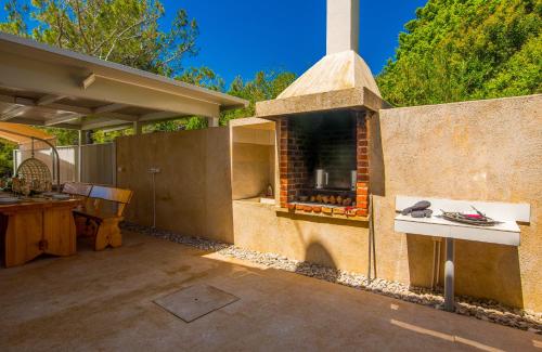 a outdoor kitchen with a stone fireplace in a backyard at Villa St. Martin-Reef in Martinšćica