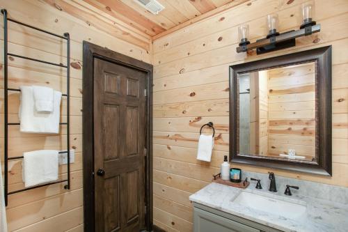 a bathroom with a sink and a mirror at Smoky Ridge Hideaway Views Hot Tub Game Room in Sevierville