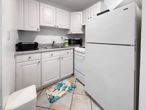 ハリウッドにあるHollywood Sunriseの白いキャビネットと白い冷蔵庫のあるキッチン