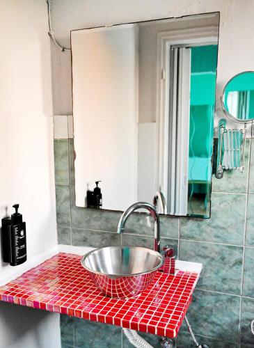 a red counter with a sink in a bathroom at Karmik Concept Apartments in Afantou