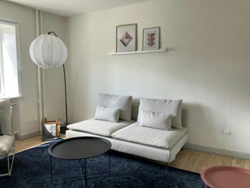 Una sala de estar con un sofá blanco y dos mesas. en Convenient Studio for 2, en Esbjerg