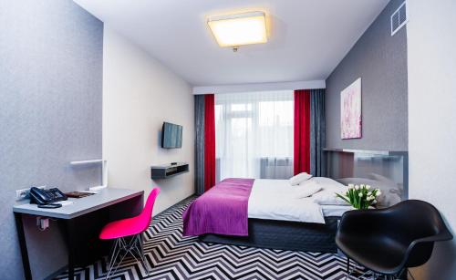 a hotel room with a bed and a desk and a chair at Hotel Wyspiański in Krakow