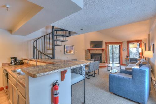 a kitchen and living room with a spiral staircase at Wedgewood Lodge in Breckenridge