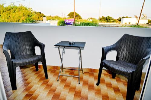 アファンドウにあるKarmik Concept Apartmentsの部屋に椅子2脚とテーブル1台