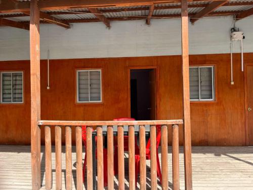 a wooden building with a door and a fence at Agro Camping Los Costeños in Choapa