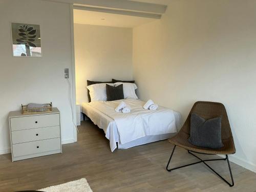 une chambre avec un lit avec une commode et une chaise dans l'établissement Convenient Studio for 2, à Esbjerg