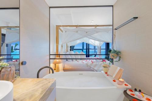 een slaapkamer met een wit bed en een grote spiegel bij Sapphire Oceanview Suite in Gold Coast