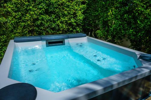 a hot tub on top of a patio with trees at Daline Holiday Rooms in Acquarica del Capo